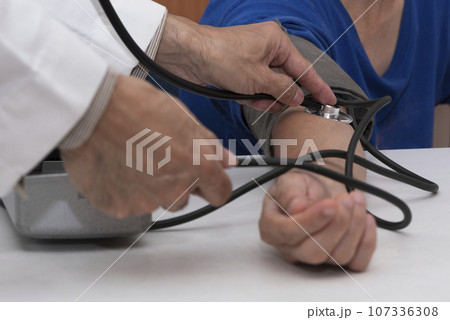 Doctor measuring blood prssure of a patient Doctor measuring blood prssure of a patient 107336308