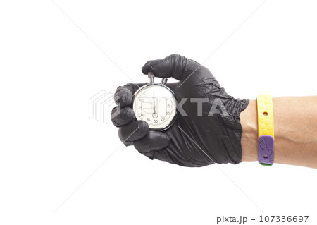 doctor's hand in black surgical medical gloves holds an activated mechanical stopwatch 107336697