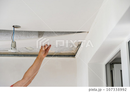 Worker assemble a suspended ceiling. 107338992