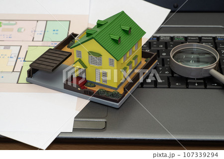 パソコンに置いた間取り図と住宅模型 107339294