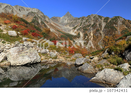 槍ヶ岳を望む紅葉の天狗池と鏡槍 107342431