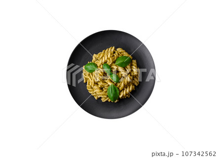 Delicious fresh pasta with green pesto sauce with basil Delicious fresh pasta with green pesto sauce with basil 107342562