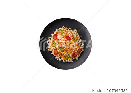 Delicious Asian cuisine dish with rice noodles, peppers, mushrooms and spices 107342583