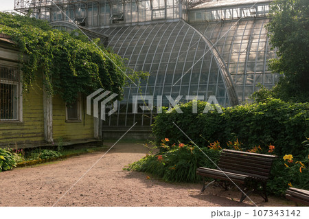 corner of an old botanical garden with a huge vintage greenhouse in the background corner of an old botanical garden with a huge vintage greenhouse in the background 107343142