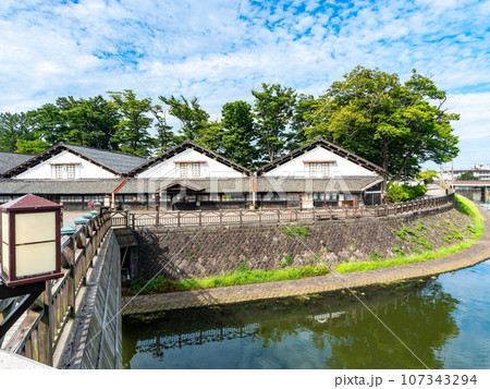 夏に訪れた川越しに眺める美しい酒田市の山居倉庫　歴史的建物 107343294