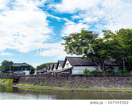 夏に訪れた川越しに眺める美しい酒田市の山居倉庫　歴史的建物 107343302