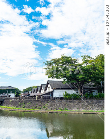 夏に訪れた川越しに眺める美しい酒田市の山居倉庫　歴史的建物 107343303