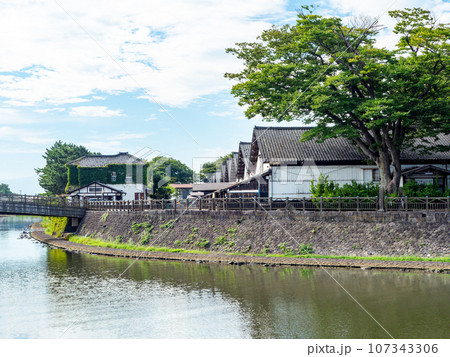 夏に訪れた川越しに眺める美しい酒田市の山居倉庫　歴史的建物 107343306