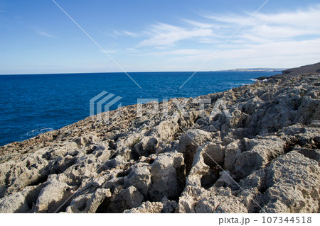 MELLIEHA, MALTA - 01 JAN, 2020: Interesting rock formations along coastline with Mediterranean Sea in the background MELLIEHA, MALTA - 01 JAN, 2020: Interesting rock formations along coastline with Mediterranean Sea in the background 107344518