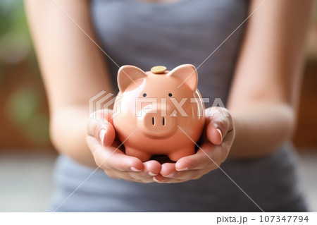 Woman's hand holding a coin in a piggy bank. Generative AI 107347794