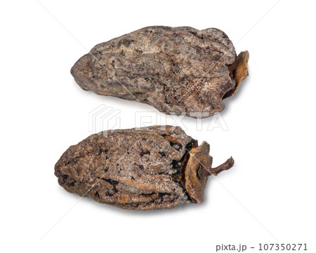 Dried persimmon on a white background. Dry fruits of the tree. Dried fruit isolate. Wrinkled persimmon. Sample. Healthy food concept. Place for an inscription Dried persimmon on a white background. Dry fruits of the tree. Dried fruit isolate. Wrinkled persimmon. Sample. Healthy food concept. Place for an inscription 107350271