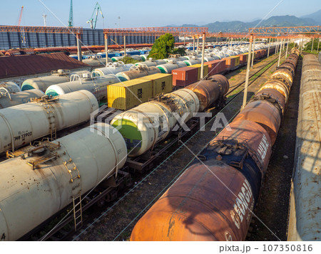 Railroad in the city against the backdrop of mountains.. Many railway paths. Wagons and trains on the tracks. unloading station. Tank wagons. Railroad in the city against the backdrop of mountains.. Many railway paths. Wagons and trains on the tracks. unloading station. Tank wagons. 107350816