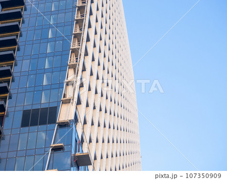 Part of a high-rise building under construction. End of construction. Finished works. Facade of a new beautiful skyscraper. Modern engineering. Part of a high-rise building under construction. End of construction. Finished works. Facade of a new beautiful skyscraper. Modern engineering. 107350909