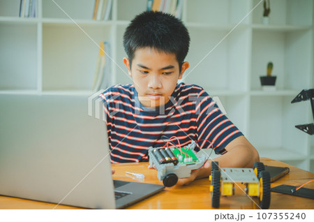 Asian boy learning and studying the work of technology robots.homeschool and science for tech project. playing childhood kids hobby leisure lifestyle people toys robotics technology. 107355240