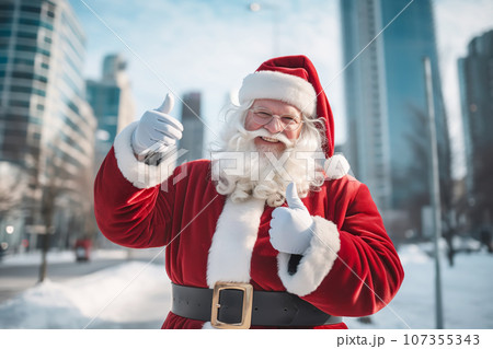 Santa Claus shows two thumb up on snow winter street with skyscrapers 107355343