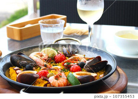 美味しそうな海鮮パエリヤと白ワイン 美味しそうな海鮮パエリヤと白ワイン 107355453