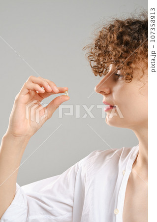 Woman holds pill in hand Woman holds pill in hand 107358913