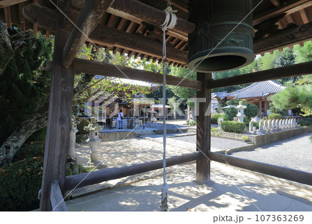 四国八十八箇所霊場第72番札所「曼荼羅寺」大師堂とお遍路さんを鐘楼越しに見る 四国八十八箇所霊場第72番札所「曼荼羅寺」大師堂とお遍路さんを鐘楼越しに見る 107363269