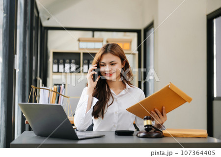 Beautiful asian woman lawyer working and gavel, tablet, laptop in front, Advice justice and law concept. 107364405