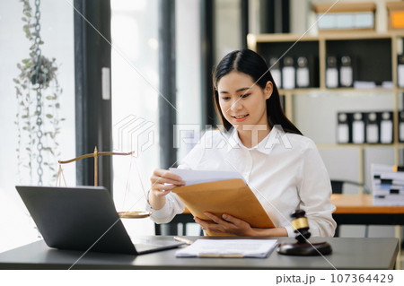 Beautiful asian woman lawyer working and gavel, tablet, laptop in front, Advice justice and law concept. Beautiful asian woman lawyer working and gavel, tablet, laptop in front, Advice justice and law concept. 107364429