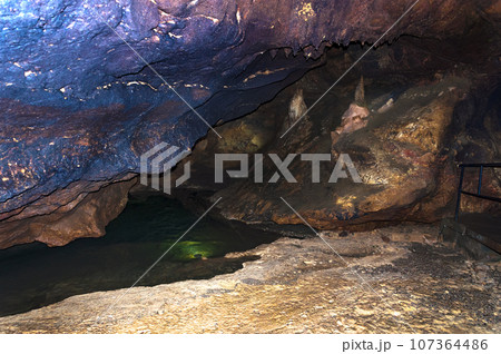 Stalactite, stalagmite on the walls of the cave. Cave lake. Template for design. 107364486