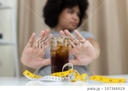 Close up sweet drink with waist measuring tape, Dieting healthy concept, lose weight, healthy diet. Close up sweet drink with waist measuring tape, Dieting healthy concept, lose weight, healthy diet. 107366029