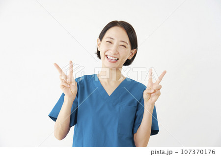 両手でピースサインをする女性の医者 白背景 両手でピースサインをする女性の医者 白背景 107370176