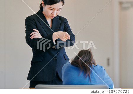 腕組みをして女の子を叱る女性の教師 腕組みをして女の子を叱る女性の教師 107370723