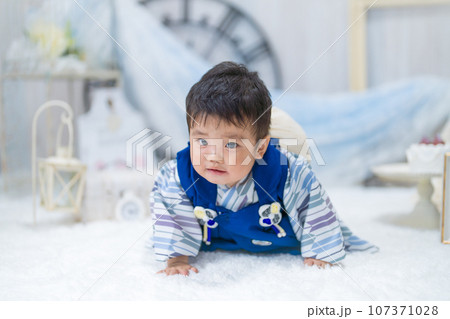 バースデーフォトセットで1歳の誕生日に一生餅を背負ってハイハイするつらそうな表情の赤ちゃん バースデーフォトセットで1歳の誕生日に一生餅を背負ってハイハイするつらそうな表情の赤ちゃん 107371028