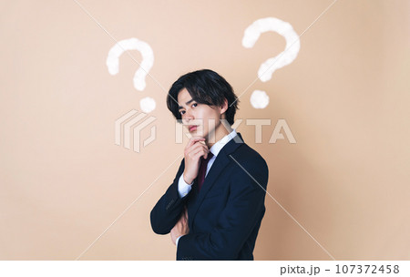 考えこむスーツを着た若い男性　ビジネスマン 107372458