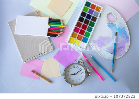 Back to school, watercolor paints, brushes and colored pencils, palette, school supplies on a gray background, top view Back to school, watercolor paints, brushes and colored pencils, palette, school supplies on a gray background, top view 107372822