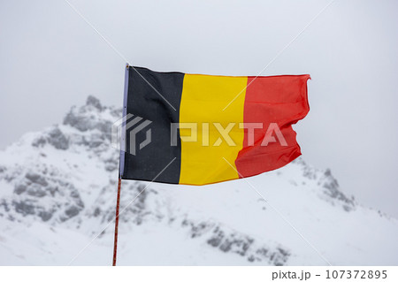 Belgium national flag against winter mountains 107372895