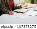 Concept of business office woman working,Businesswoman smile while working about her invesment plan with analyzing document and business investment graph data by using laptop on desk in workstation. 107373275