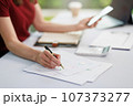 Concept of business office woman working,Businesswoman smile while working about her invesment plan with analyzing document and business investment graph data by using laptop on desk in workstation. 107373277