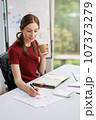 Concept of business office woman working,Businesswoman smile while working about her invesment plan with analyzing document and business investment graph data by using laptop on desk in workstation. 107373279
