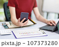 Concept of business office woman working,Businesswoman smile while working about her invesment plan with analyzing document and business investment graph data by using laptop on desk in workstation. 107373280