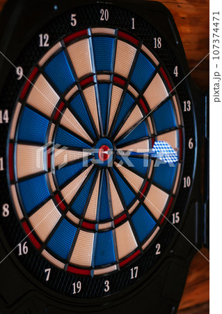 Close-up. Bright multicolored dartboard hangs on wall. Games and entertainment. Excitement , sport. Close-up. Bright multicolored dartboard hangs on wall. Games and entertainment. Excitement , sport. 107374471