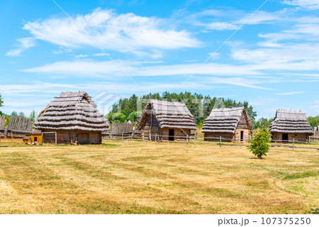 Small medieval village of shepherd huts with straw roof on sunny day. Small medieval village of shepherd huts with straw roof on sunny day. 107375250