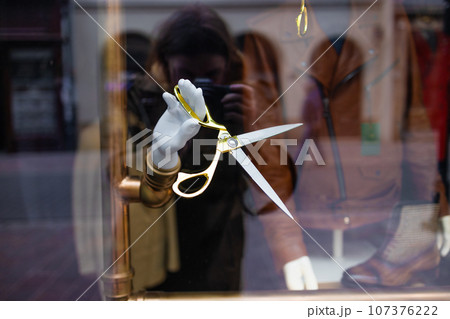 Mannequin hand holding hair scissors from the shopping windows. Minimalism beauty concept 107376222