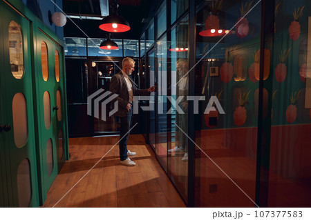 Businessman enters password lock code on alarm panel in office door for entering Businessman enters password lock code on alarm panel in office door for entering 107377583