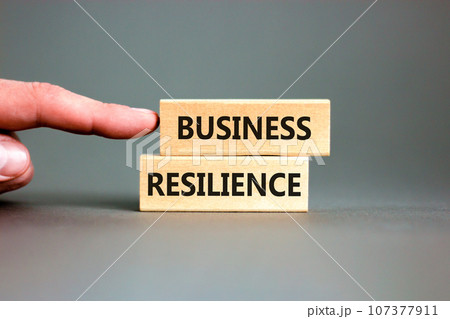 Business resilience symbol. Concept word Business resilience typed on wooden blocks. Beautiful grey table grey background. Businessman hand. Business and business resilience concept. Copy space. 107377911
