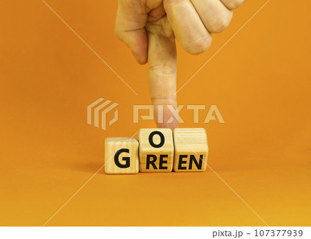 Ecology and go green symbol. Concept words Go green on wooden cubes. Businessman hand. Beautiful orange table orange background. Business ecological and go green concept. Copy space. 107377939
