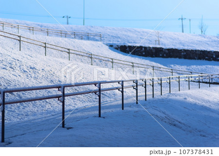 大雪の積もった手すり付きのジグザクした斜面 大雪の積もった手すり付きのジグザクした斜面 107378431
