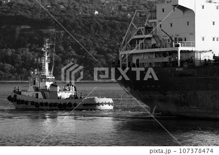 Tug boat is near a cargo ship. Black sea, Varna harbo Tug boat is near a cargo ship. Black sea, Varna harbo 107378474