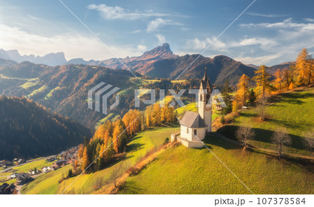 Aerial view of beautiful church, green meadows, orange trees 107378584