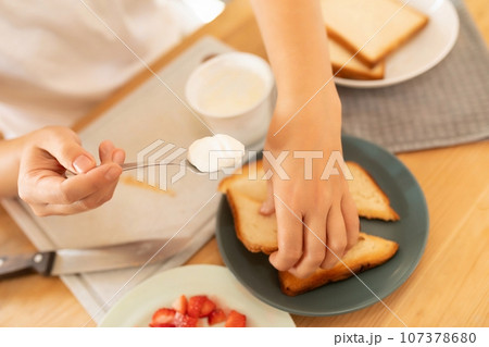 the woman sliced the cooked bread slices into triangles the woman sliced the cooked bread slices into triangles 107378680