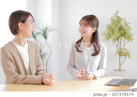 1on1_仕事の状況を話す部下と聞いている女性管理職_1 1on1_仕事の状況を話す部下と聞いている女性管理職_1 107379374