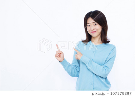 白い背景の前で人差し指を立てる30代の女性 白い背景の前で人差し指を立てる30代の女性 107379897