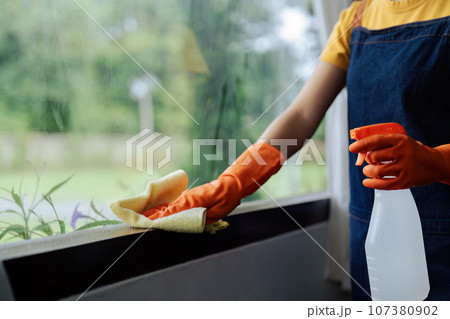 Woman wiping the edge window with microfiber cloth. Close-up detail. Housekeeping concept Woman wiping the edge window with microfiber cloth. Close-up detail. Housekeeping concept 107380902