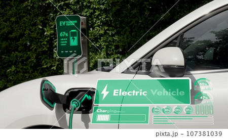 Electric car plug into EV charger display battery status hologram.Peruse Electric car plug into EV charger display battery status hologram.Peruse 107381039
